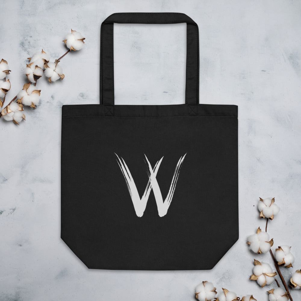 A minimalist sumi-e brush stroke design of the capital letter W printed on a tote bag. Flat lay, Ink colourway.