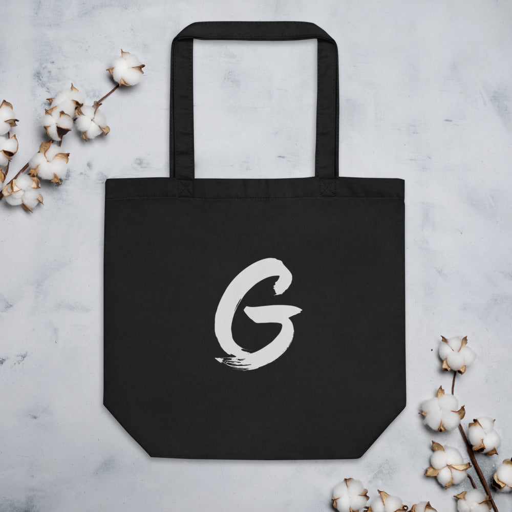 Sumi-e brush stroke of the capital letter G printed on a tote bag. Flat lay, Ink colourway.