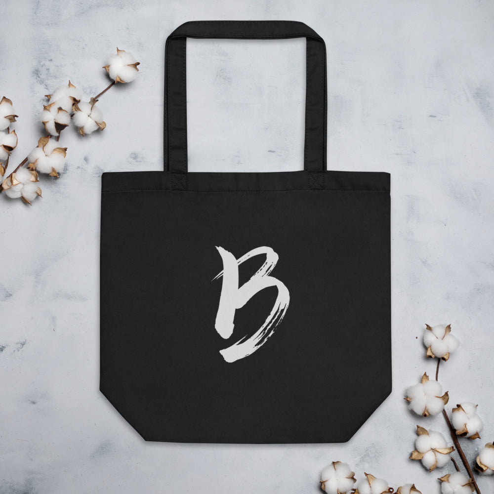 The capital letter B printed in minimalist sumi-e black ink on a tote bag. Flat lay, Ink colourway.
