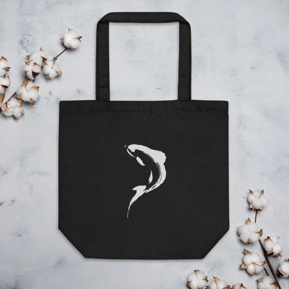 A minimalist sumi-e brushstroke of a rising trout back and tail printed on a tote bag. Flat lay, Ink colourway.