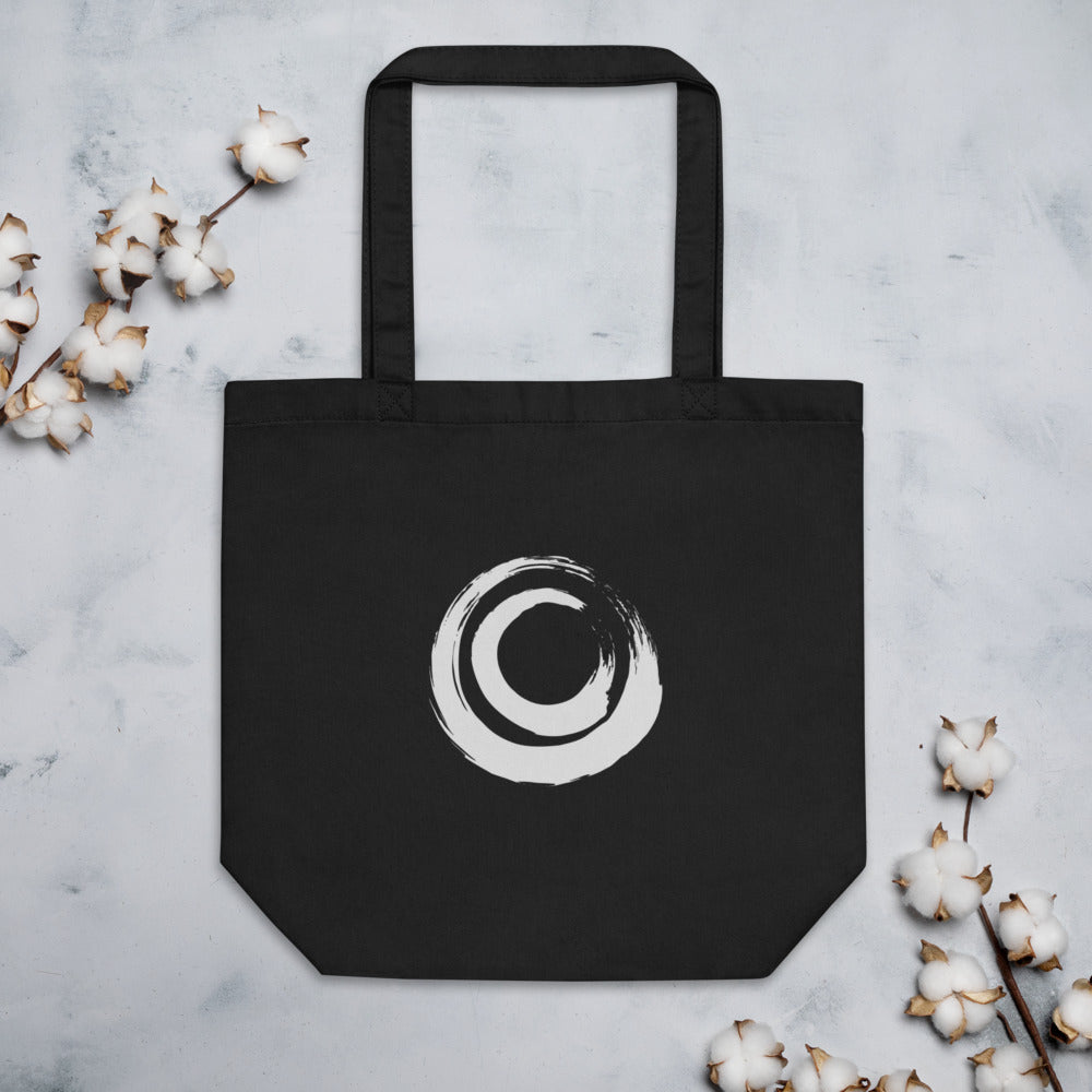 A nested double circle sumi-e brushstroke design printed on a tote bag. Flat lay, Ink colourway.