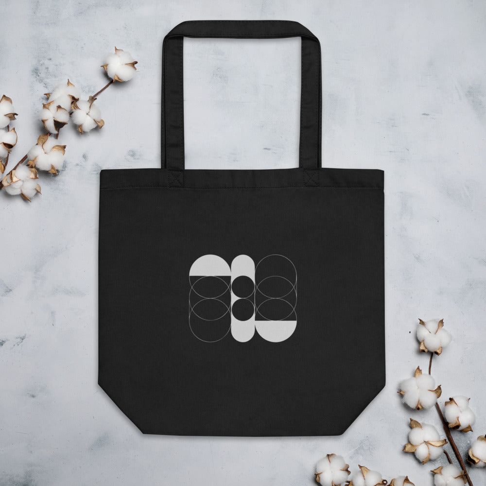 A sequence of nested Cassini ovals in fine hairline weight, transitioning from two loops to a flattened ellipse on a tote bag. Flat lay, Ink colourway.