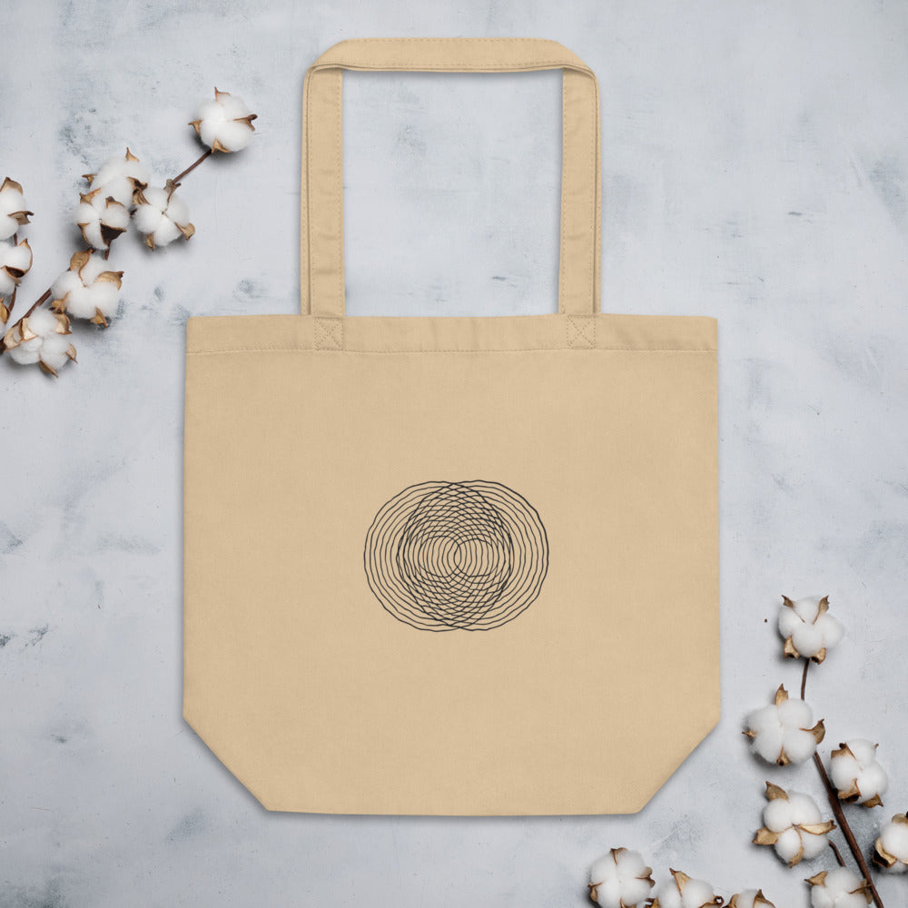 A minimalist diagram of intersecting concentric raindrop ripple rings printed on a tote bag. Flat lay, Bone colourway.
