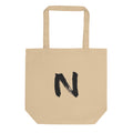 A minimal black sumi-e ink brush stroke of the letter N printed on a canvas tote bag. Shown on the Bone (Oyster) colorway.