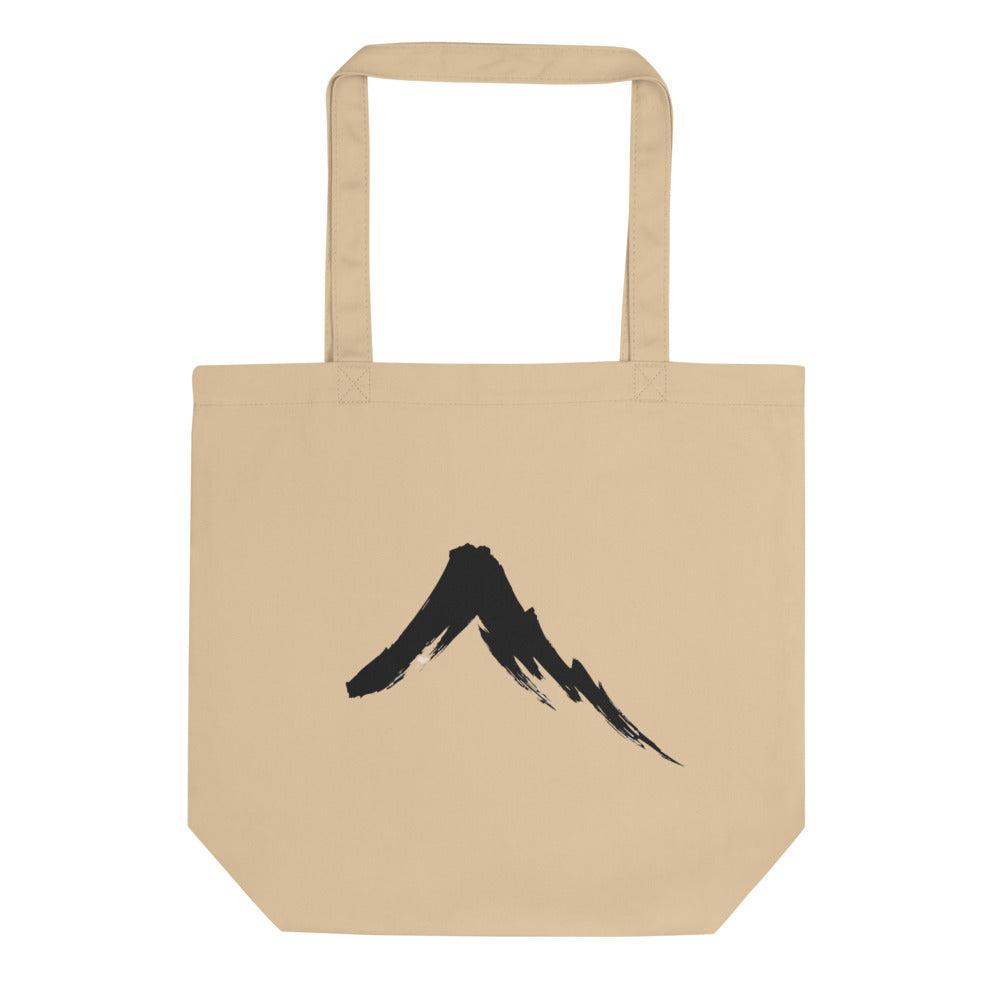 A single downward sumi-e ink brush stroke depicting a steep volcanic mountain slope on a tote bag. Shown on the Bone (Oyster) colorway.