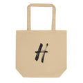 The capital letter H rendered in black sumi-e brushstrokes printed on a tote bag. Shown on the Bone (Oyster) colorway.