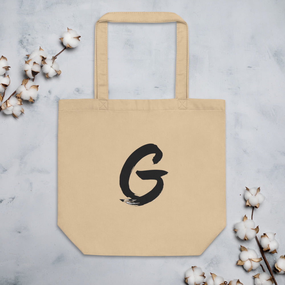 Sumi-e brush stroke of the capital letter G printed on a tote bag. Flat lay, Bone colourway.