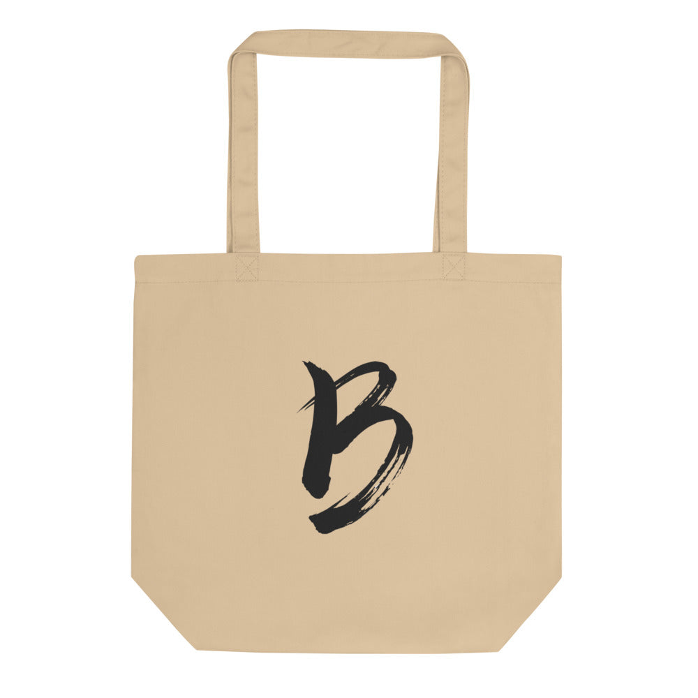 The capital letter B printed in minimalist sumi-e black ink on a tote bag. Shown on the Bone (Oyster) colorway.