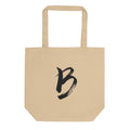The capital letter B printed in minimalist sumi-e black ink on a tote bag. Shown on the Bone (Oyster) colorway.