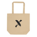 A black ink sumi-e calligraphy letter X printed on a canvas tote bag. Shown on the Bone (Oyster) colorway.