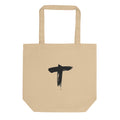 Minimalist black ink sumi-e letter T design printed on a canvas tote bag. Shown on the Bone (Oyster) colorway.