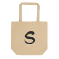 The letter S rendered in a single serpentine sumi-e brush stroke printed on a tote bag. Shown on the Bone (Oyster) colorway.