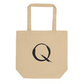 The letter Q rendered in a single minimalist sumi-e brush gesture on a tote bag. Shown on the Bone (Oyster) colorway.