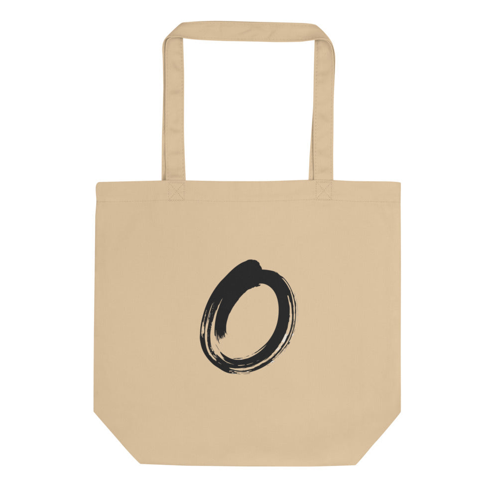 A single black sumi-e brushstroke forming an unclosed letter O on a tote bag. Shown on the Bone (Oyster) colorway.