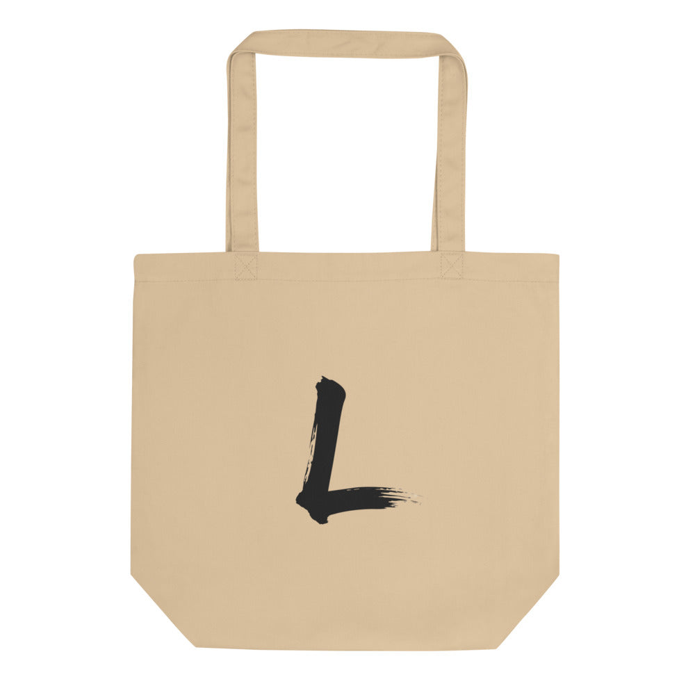 A black sumi-e brushstroke of the letter L printed on a simple tote bag. Shown on the Bone (Oyster) colorway.