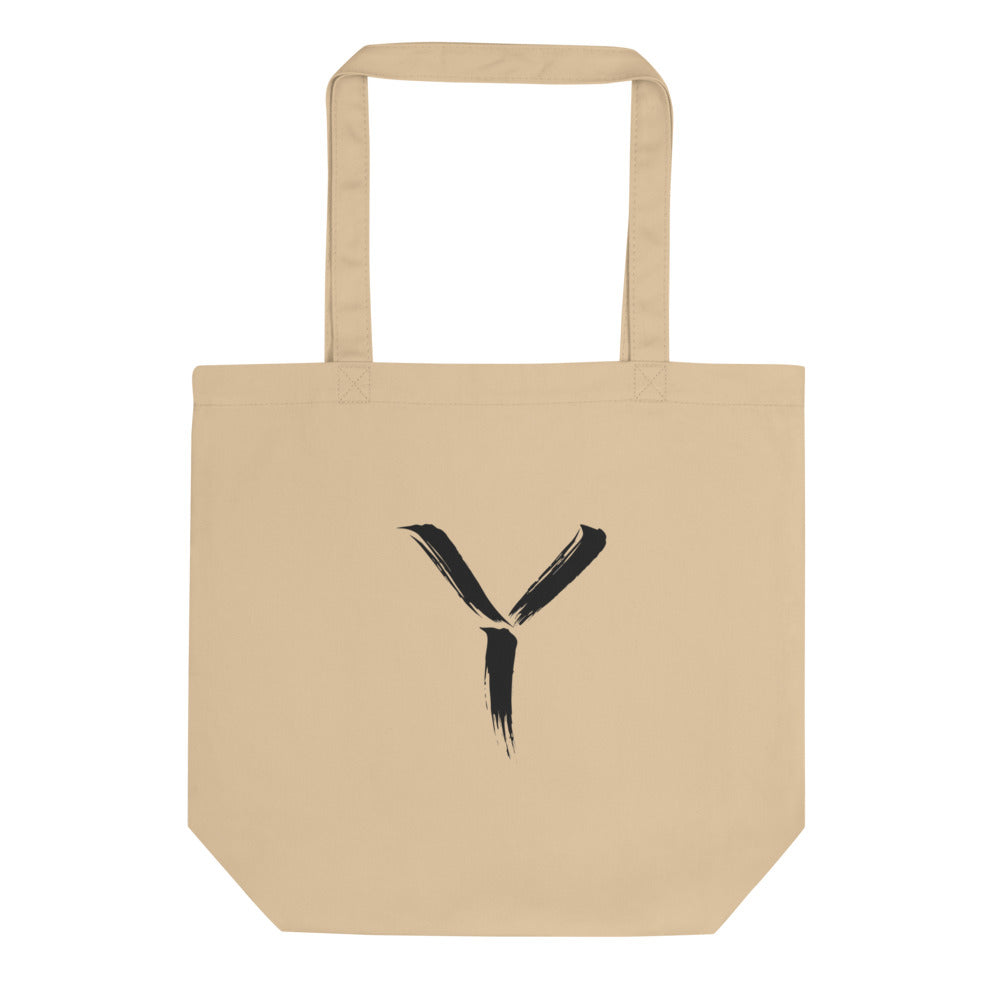 A minimalist sumi-e brush gesture of the capital letter Y printed on a canvas tote bag. Shown on the Bone (Oyster) colorway.