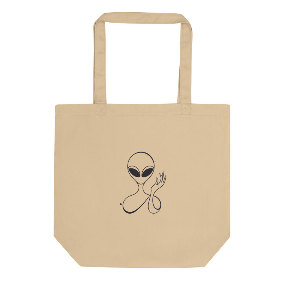 Minimalist waving visitor line art design of an alien with almond eyes raising a hand, printed on a tote bag. Shown on the Bone (Oyster) colorway.
