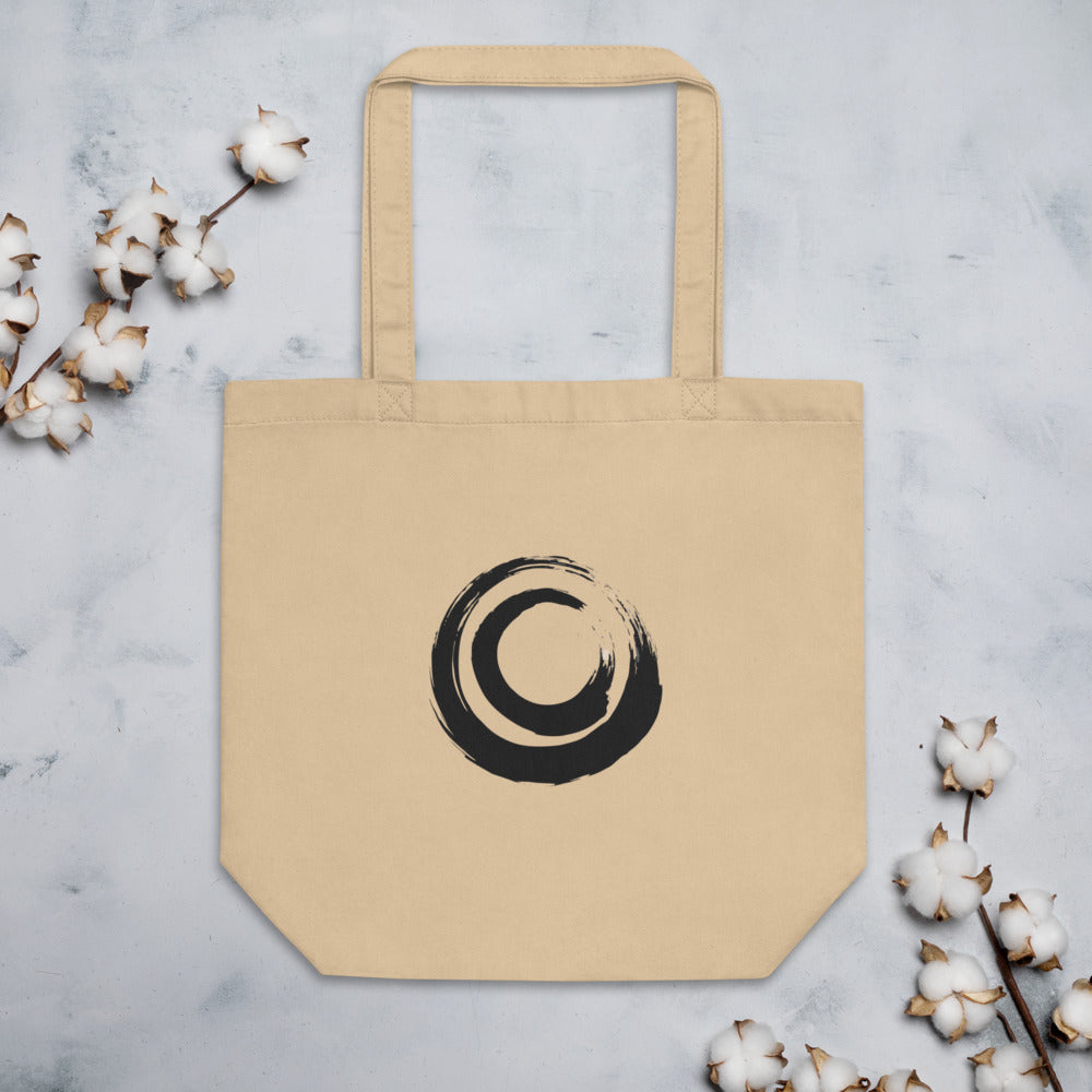 A nested double circle sumi-e brushstroke design printed on a tote bag. Flat lay, Bone colourway.
