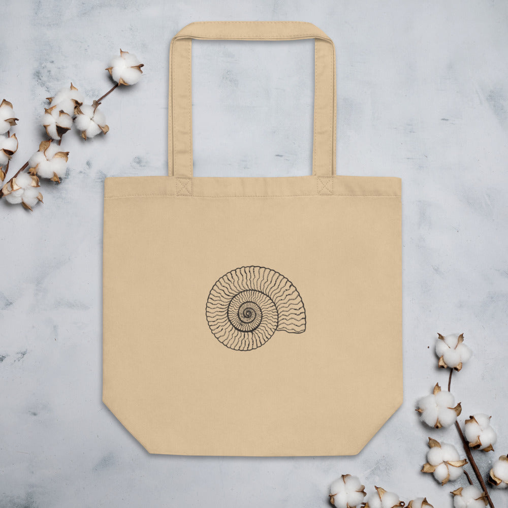 A precise line art illustration of a Dactylioceras commune ammonite in dorsal-lateral view, printed on a tote bag. Flat lay, Bone colourway.