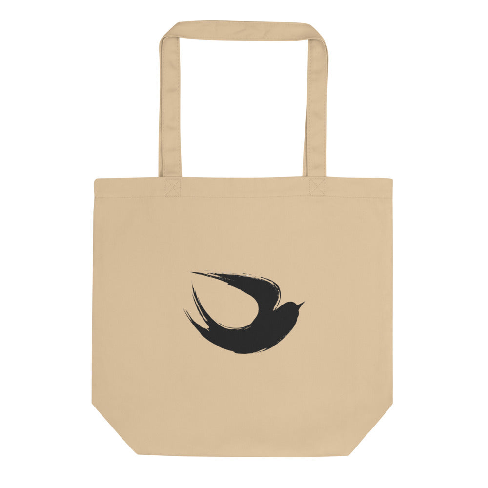 A minimalist sumi-e ink brush painting of a flying swallow on a tote bag. Shown on the Bone (Oyster) colorway.