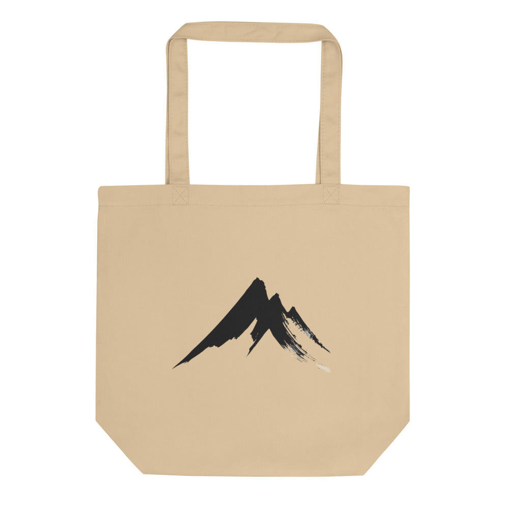 A sharp, minimalist sumi-e ink drawing of a jagged mountain peak printed on a tote bag. Shown on the Bone (Oyster) colorway.