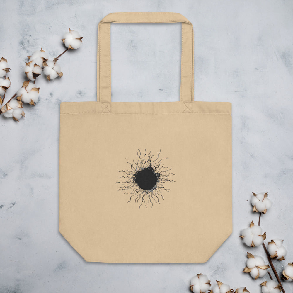 An ink-drawn diagram of a solar sunspot with radiating penumbra filaments printed on a tote bag. Flat lay, Bone colourway.