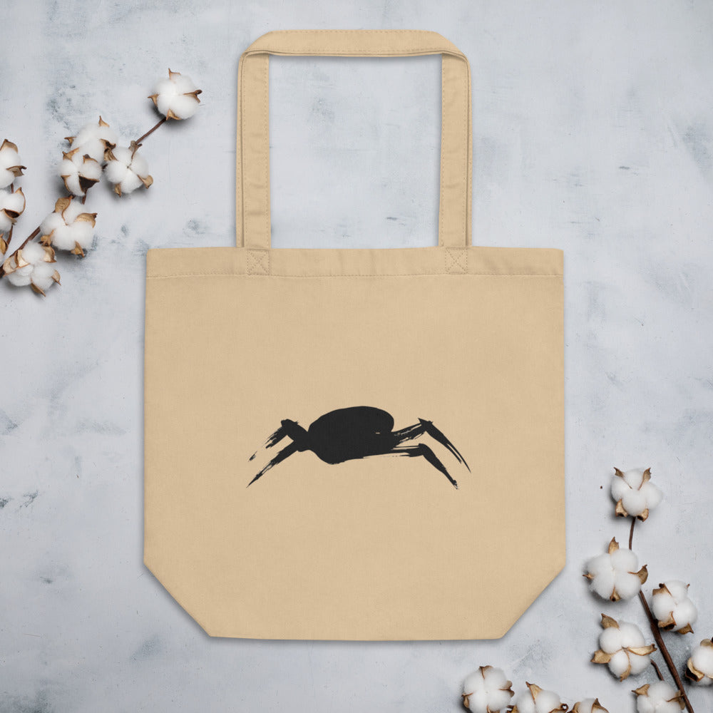 A minimalist sumi-e ink painting of a crab shell and legs printed on a tote bag. Flat lay, Bone colourway.
