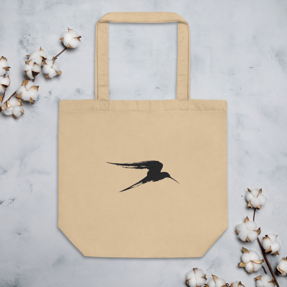 An asymmetric sumi-e ink painting of a gliding heron in flight, printed on a tote bag. Flat lay, Bone colourway.