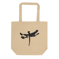 A minimalist dragonfly sumi-e ink design printed on a canvas tote bag. Shown on the Bone (Oyster) colorway.