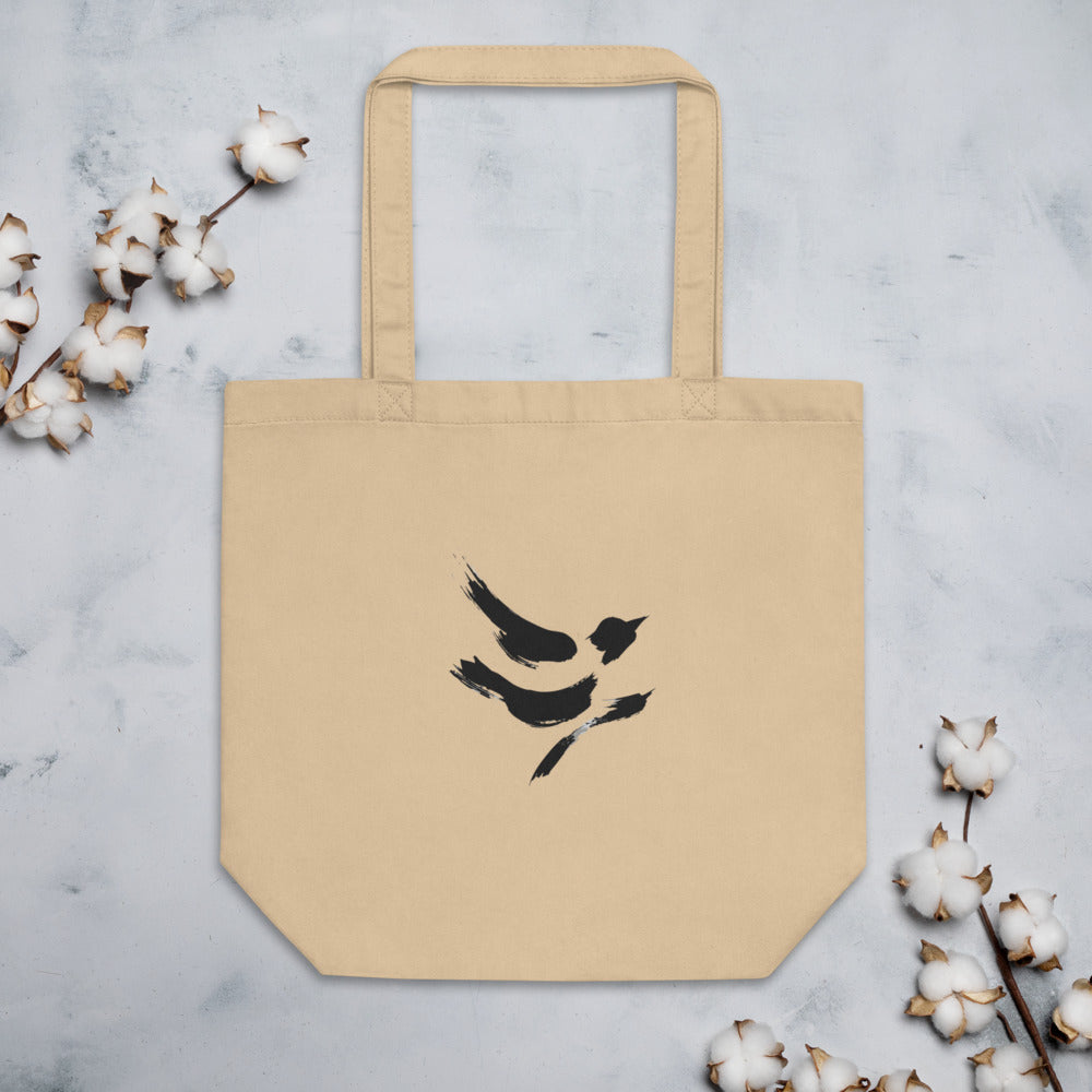 The minimal sumi-e design of a diving sparrow printed on a canvas tote bag. Flat lay, Bone colourway.