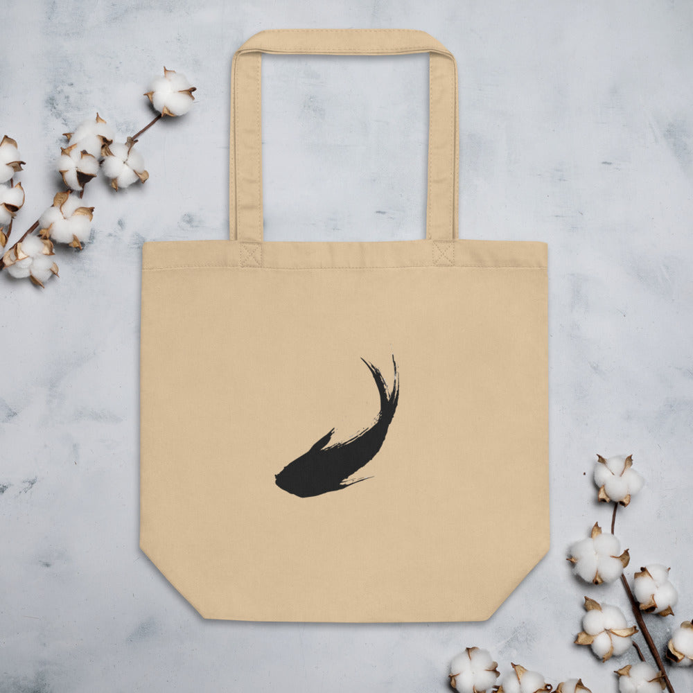 A minimal sumi-e ink brush painting of a single ascending carp printed on a tote bag. Flat lay, Bone colourway.