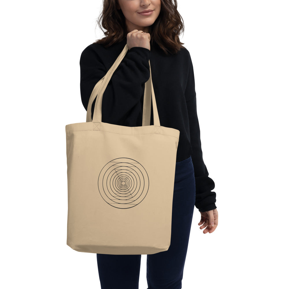 A sequence of twenty nested circles with logarithmic radial spacing on a tote bag. Carried over the shoulder, Bone colourway.