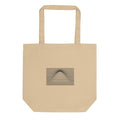 A geometric graphic of parallel horizontal lines bending upward in the center to form a Gaussian bell curve on a tote bag. Shown on the Bone (Oyster) colorway.