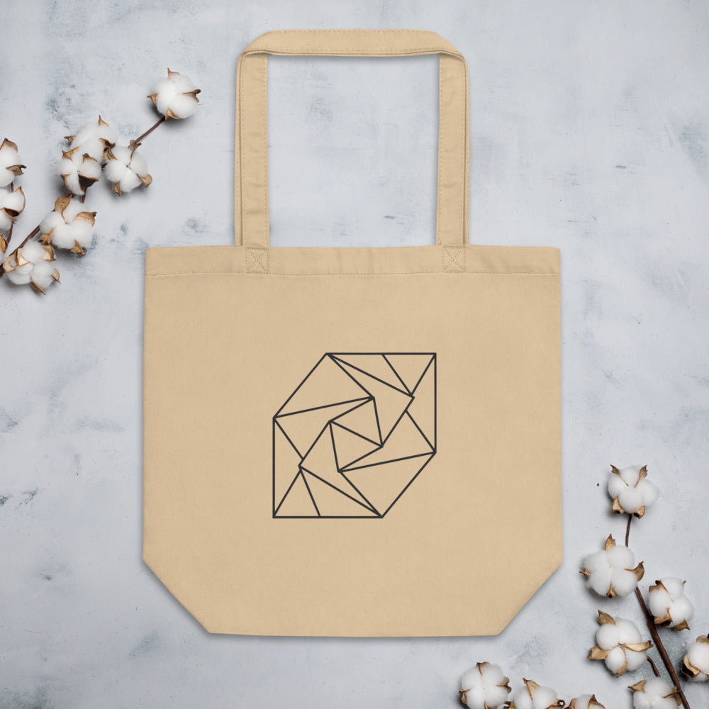 A spiral progression of twelve folded triangular planes in a hairline-weight line art print on a classic tote bag. Flat lay, Bone colourway.