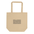 A staggered grid of ruled horizontal line segments printed in a minimalist linear abstract style on a cotton tote bag. Shown on the Bone (Oyster) colorway.