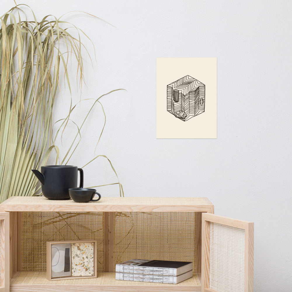 Minimalist line drawing of a square geological block showing sharp-angled chevron folds on an art print. Above a rattan cabinet, 12″×16″ size.