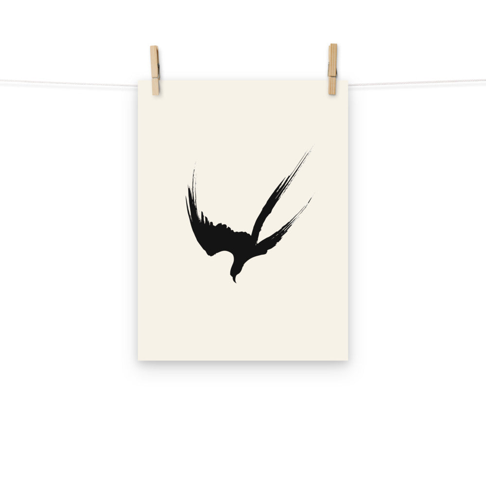 A minimalist three-stroke sumi-e hawk design with dry-brush texture printed on an art print. Hung with wooden pegs, 12″×16″ size.