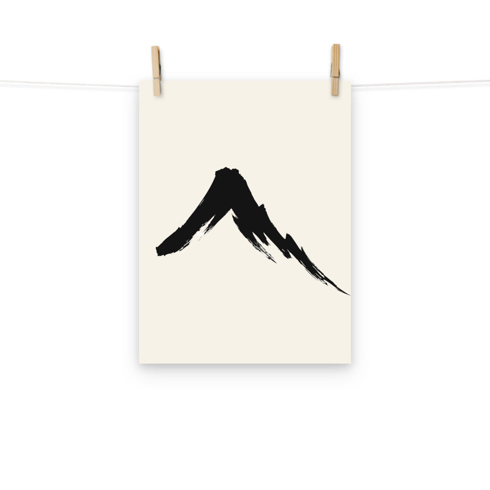 A single downward sumi-e ink brush stroke depicting a steep volcanic mountain slope on an art print. Hung with wooden pegs, 12″×16″ size.