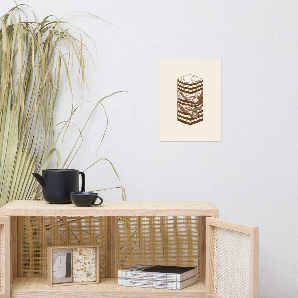 A vertical stratigraphic diagram of lake-bed varves printed as minimalist line art on an art print. Above a rattan cabinet, 12″×16″ size.