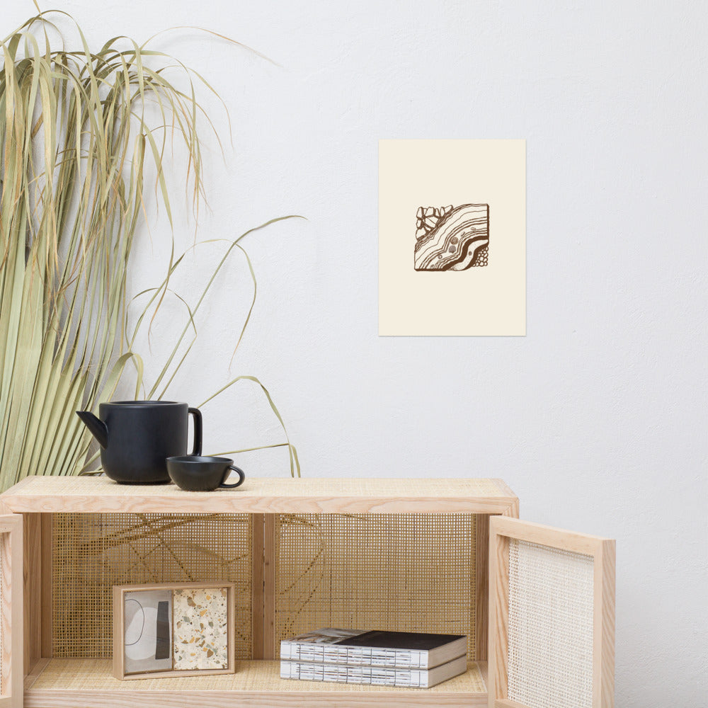 An asymmetric anticline fold stratigraphic cross-section in clean hairline line art printed on a minimalist art print. Above a rattan cabinet, 12″×16″ size.