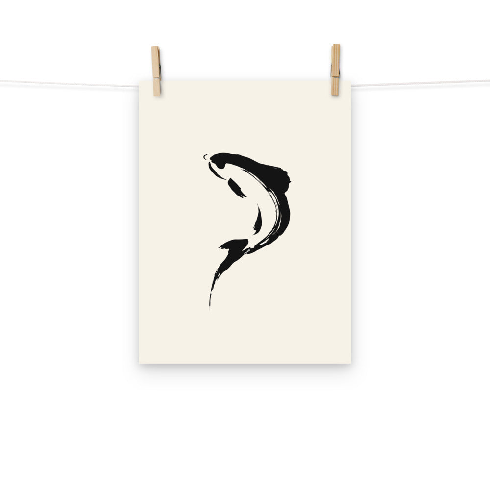 A minimalist sumi-e brushstroke of a rising trout back and tail printed on an art print. Hung with wooden pegs, 12″×16″ size.