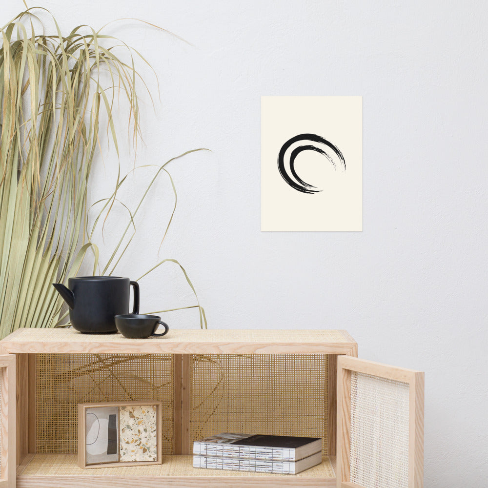 A double-layered crescent enso sumi-e painting printed on a minimalist art print. Above a rattan cabinet, 12″×16″ size.