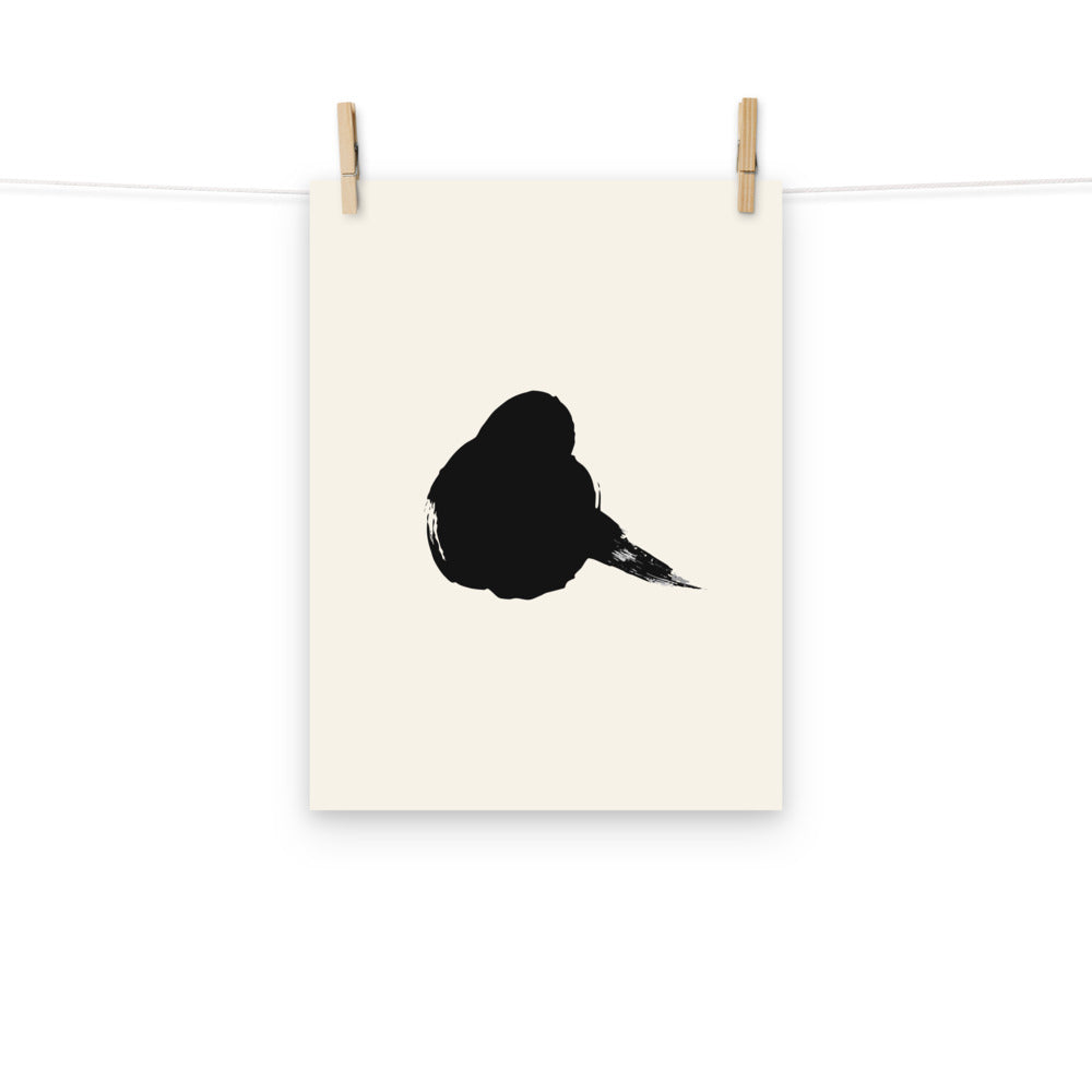 A minimalist resting sparrow printed in black sumi-e ink on an art print, showing a single wet brushstroke body. Hung with wooden pegs, 12″×16″ size.