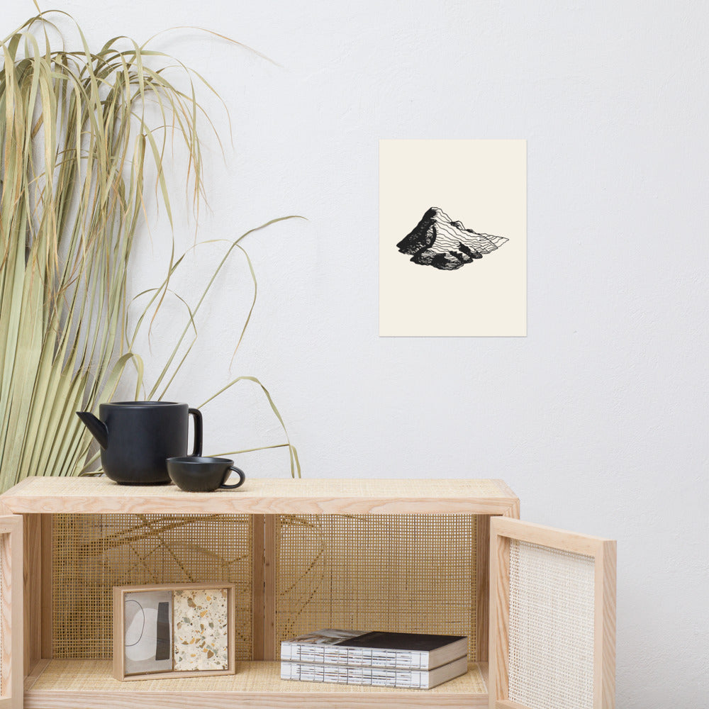 Topographic contour line art of a glacial kame terrace printed on an art print. Above a rattan cabinet, 12″×16″ size.