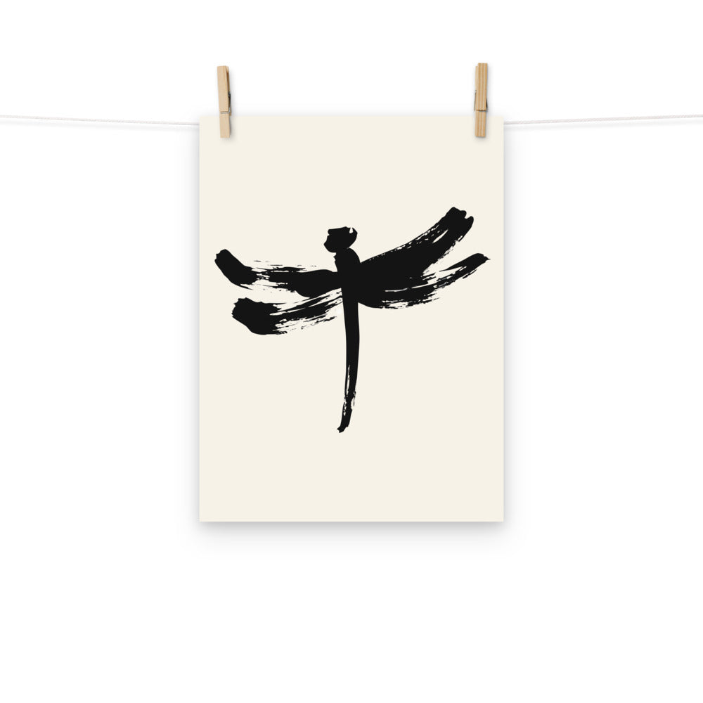 A minimalist dragonfly sumi-e ink design printed on a fine art print. Hung with wooden pegs, 12″×16″ size.