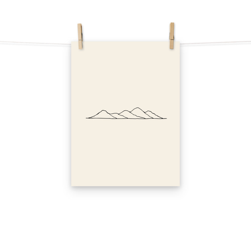 A minimalist topographic line art print showing five rolling hill peaks on an art print. Hung with wooden pegs, 12″×16″ size.