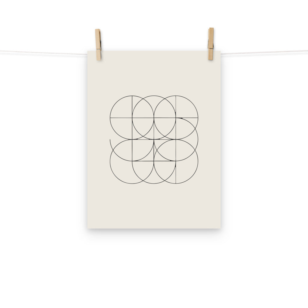 A minimalist geometric print of intersecting orthogonal circular arcs forming a bipolar grid on an art print. Hung with wooden pegs, 12″×16″ size.