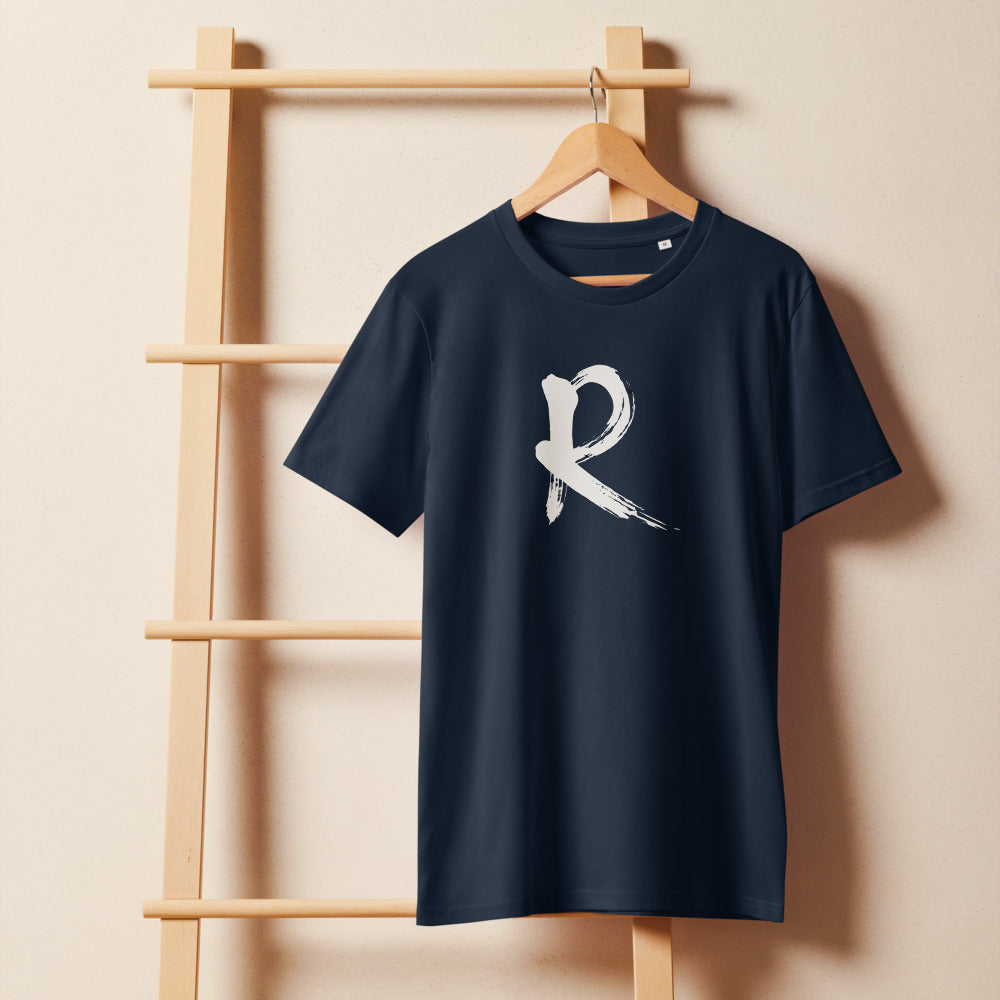 A minimalist sumi-e brush stroke design of the capital letter R printed on a t-shirt. On a wooden hanger, Ink colourway.
