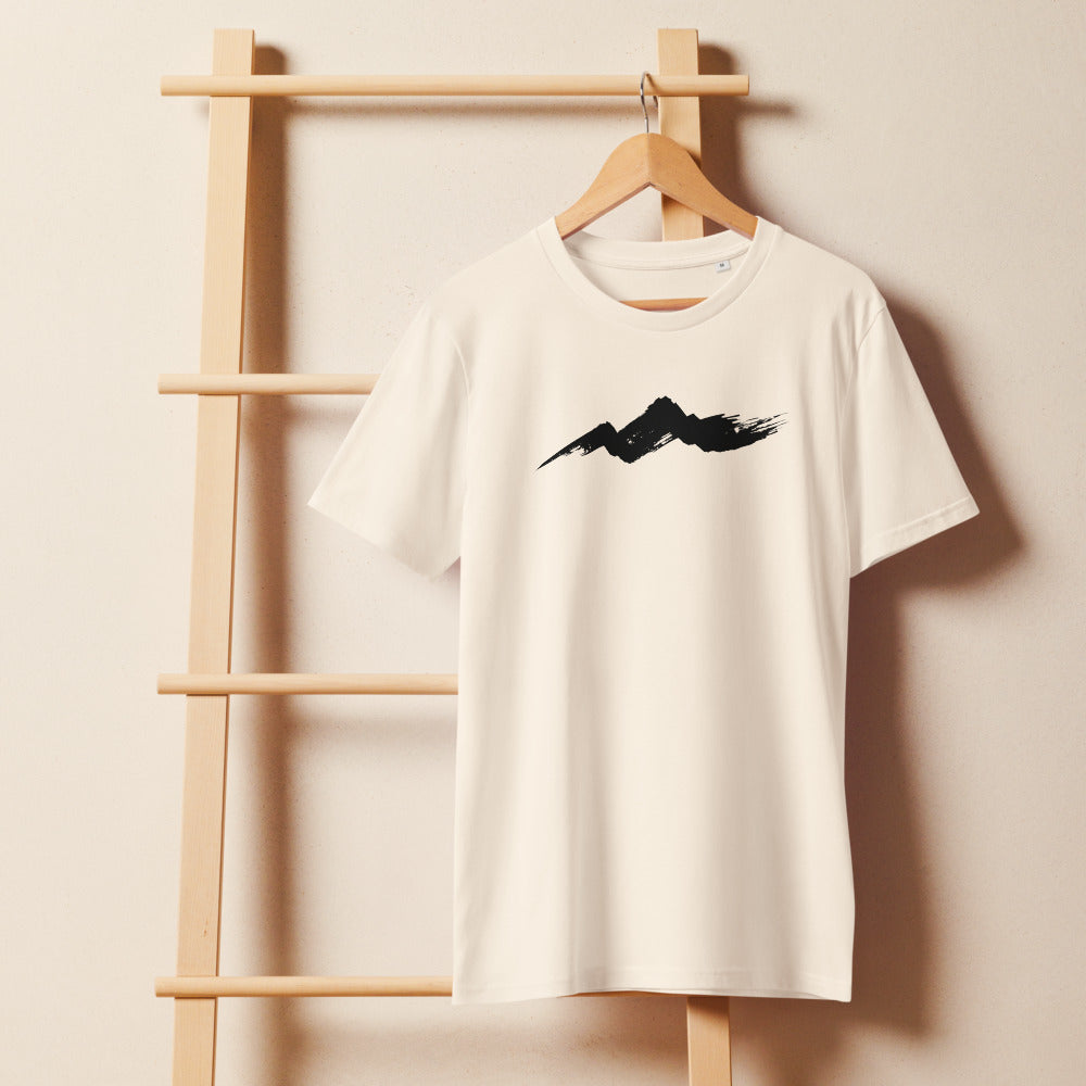 A single horizontal fractured dry-brush sumi-e ink stroke representing a rugged mountain ridge, printed on a t-shirt. On a wooden hanger, Bone colourway.
