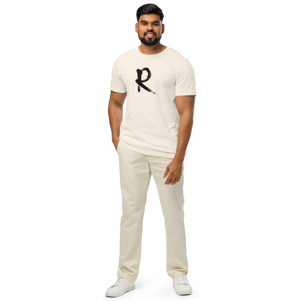 A minimalist sumi-e brush stroke design of the capital letter R printed on a t-shirt. Worn by a man, Bone colourway.